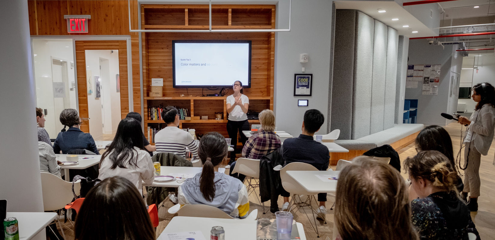 Speaker presenting in front of a group of people at a meetup